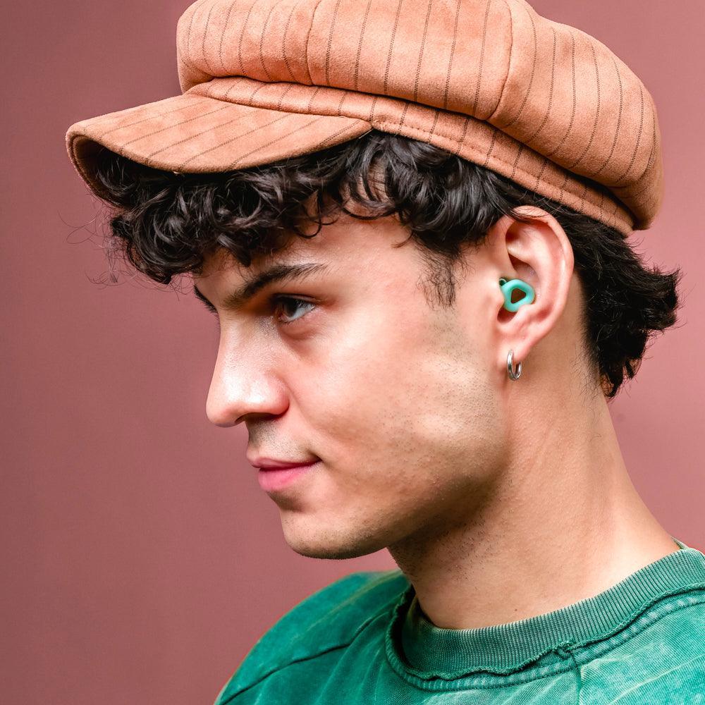 Man wearing Zenz Unwind mint green earplugs, emphasizing comfort and discreet fit for everyday activities